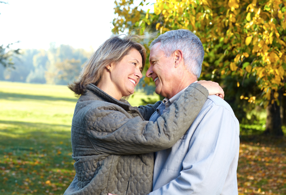 Paar 50plus umarmt sich in herbstlicher Landschaft