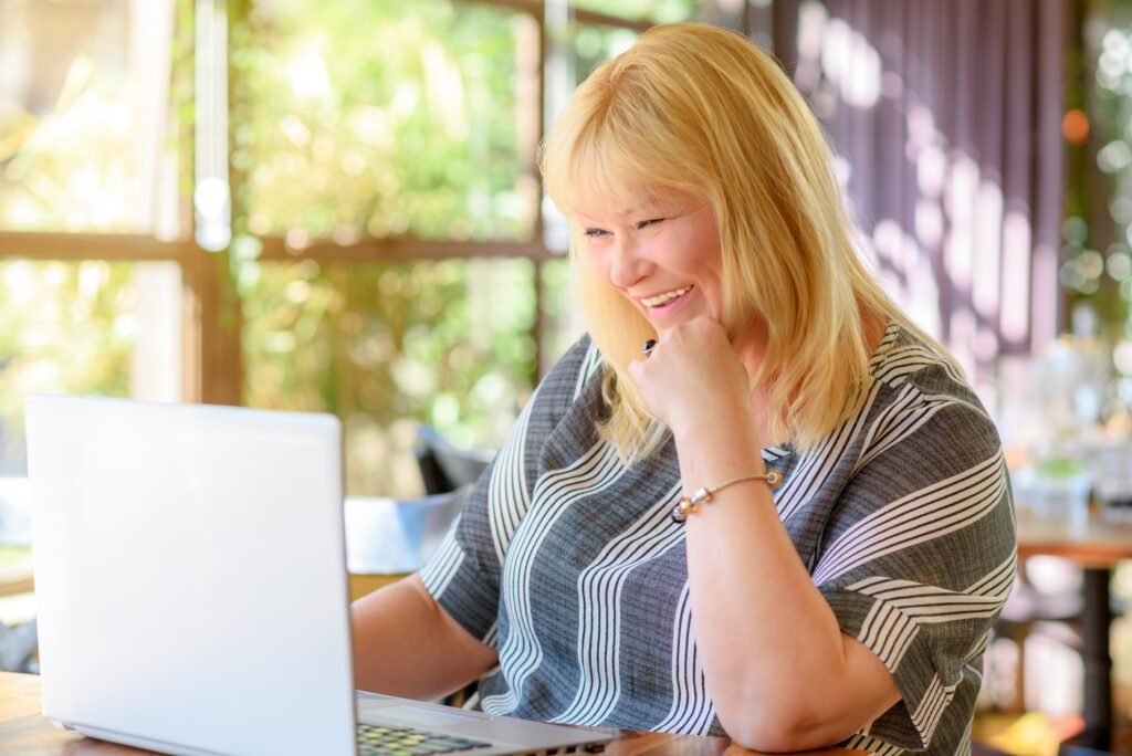 Frau sitzt vor dem Laptop und macht online dating